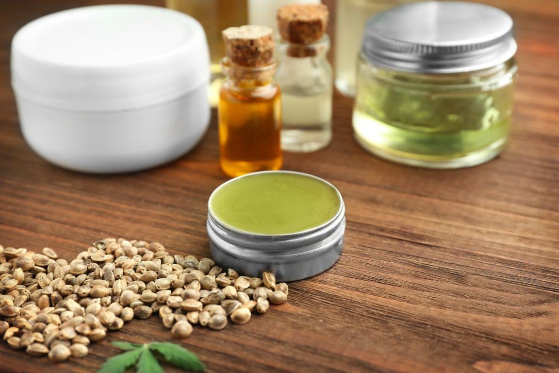 Hemp Cosmetic Products and Seeds on Wooden Background